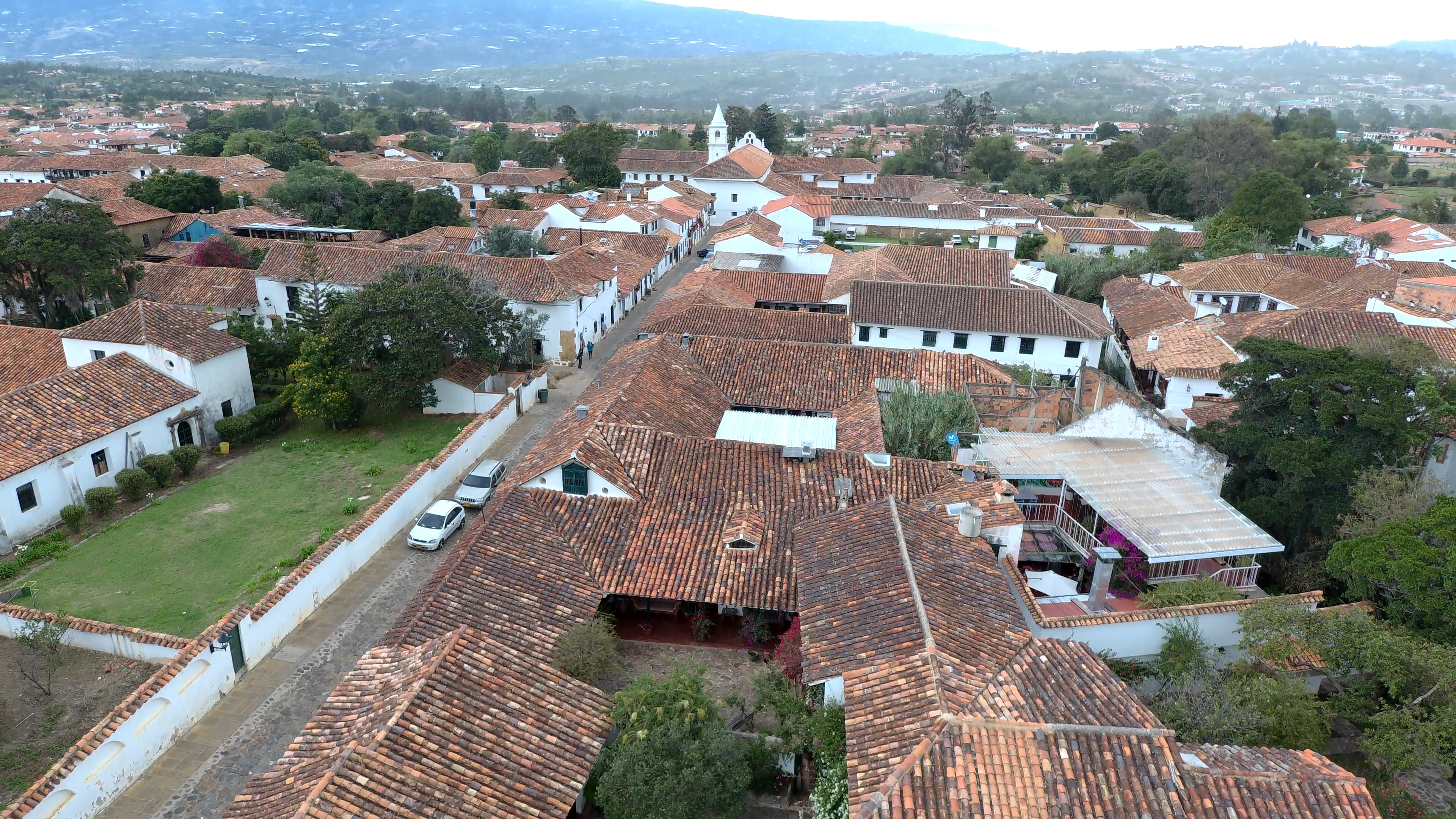Calle empedrada con fachadas blancas y tejas, estilo colonial